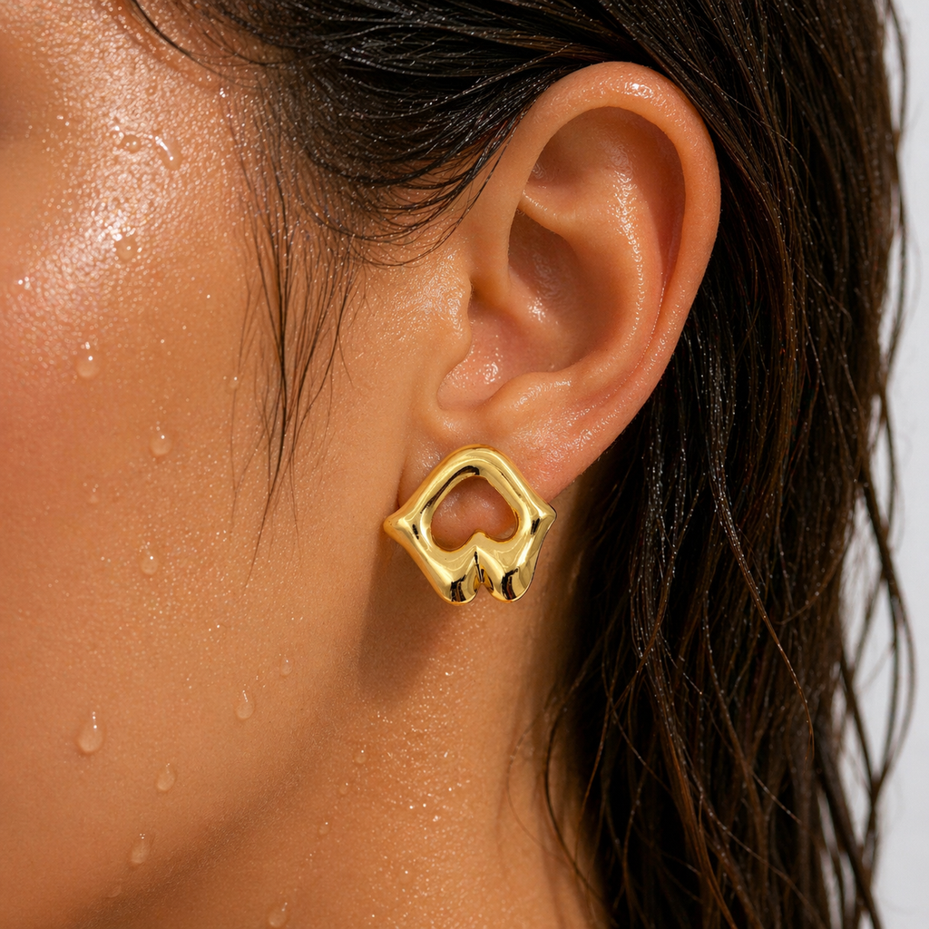 Gold-tone sculptural open-work stud earring with mirror-shine finish, shown worn on ear