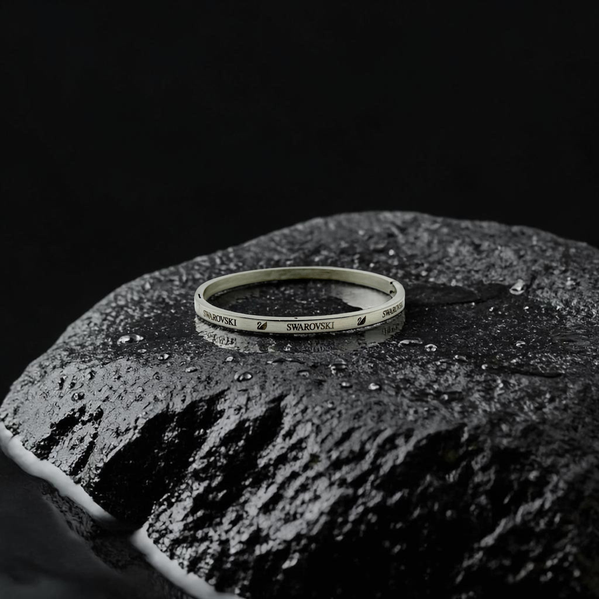 Swarovski bracelet on a textured black surface with a dark background