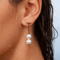 Close-up of an ear wearing a pearl earring with a blurred background