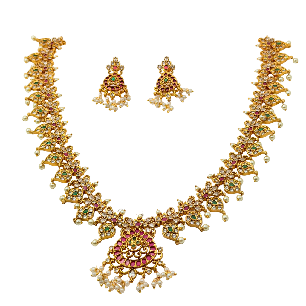 Gold necklace and earrings set with gemstones on a white background