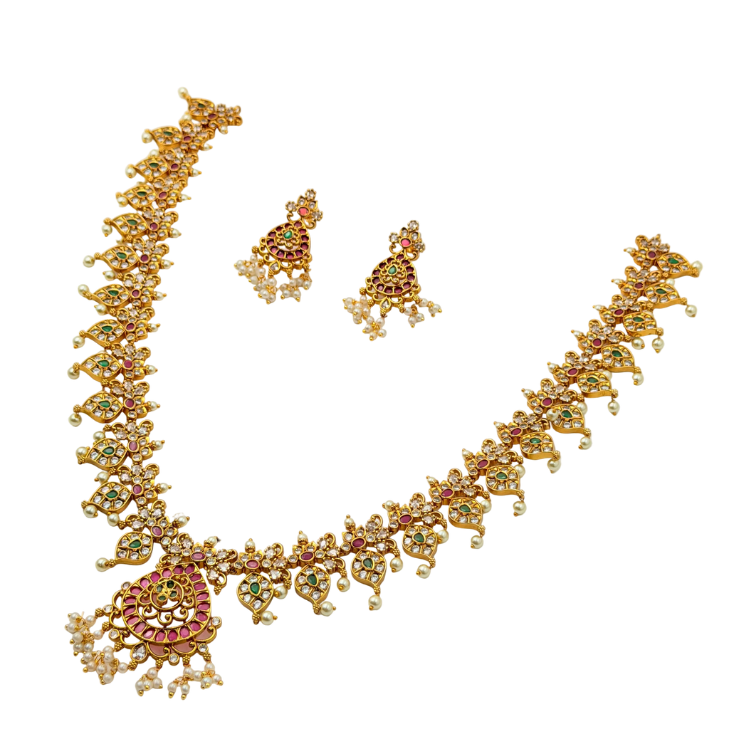 Gold necklace and earrings set with gemstones on a white background