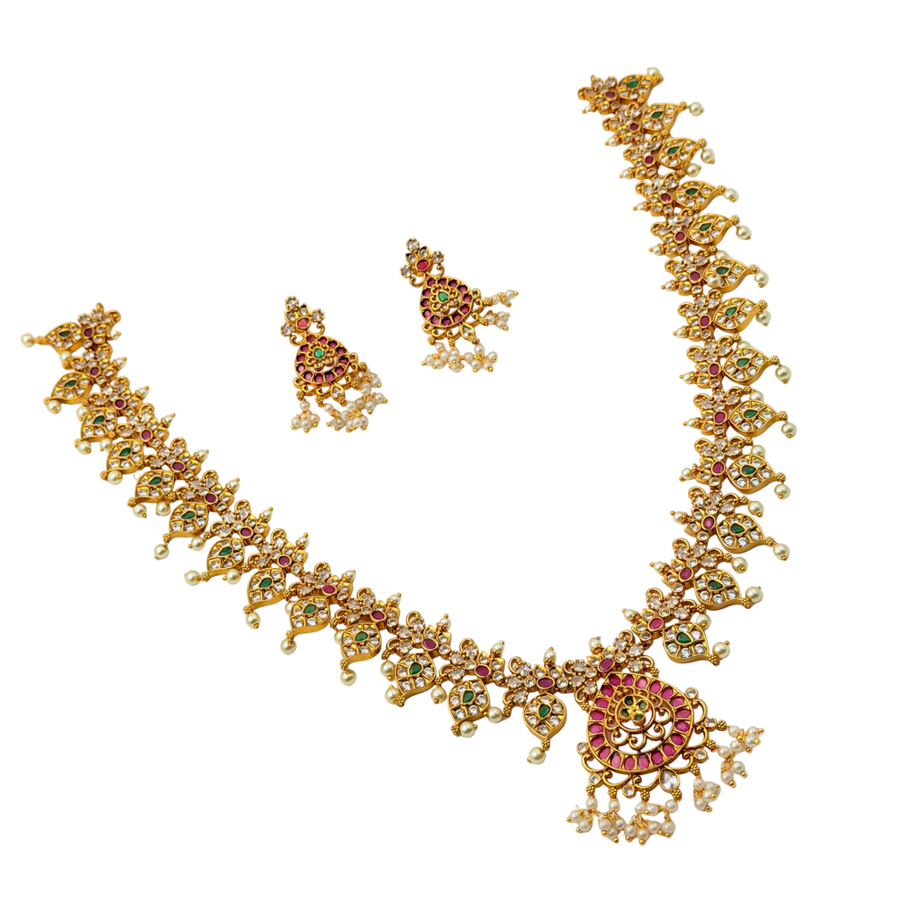 Gold necklace and earrings set with gemstones on a white background