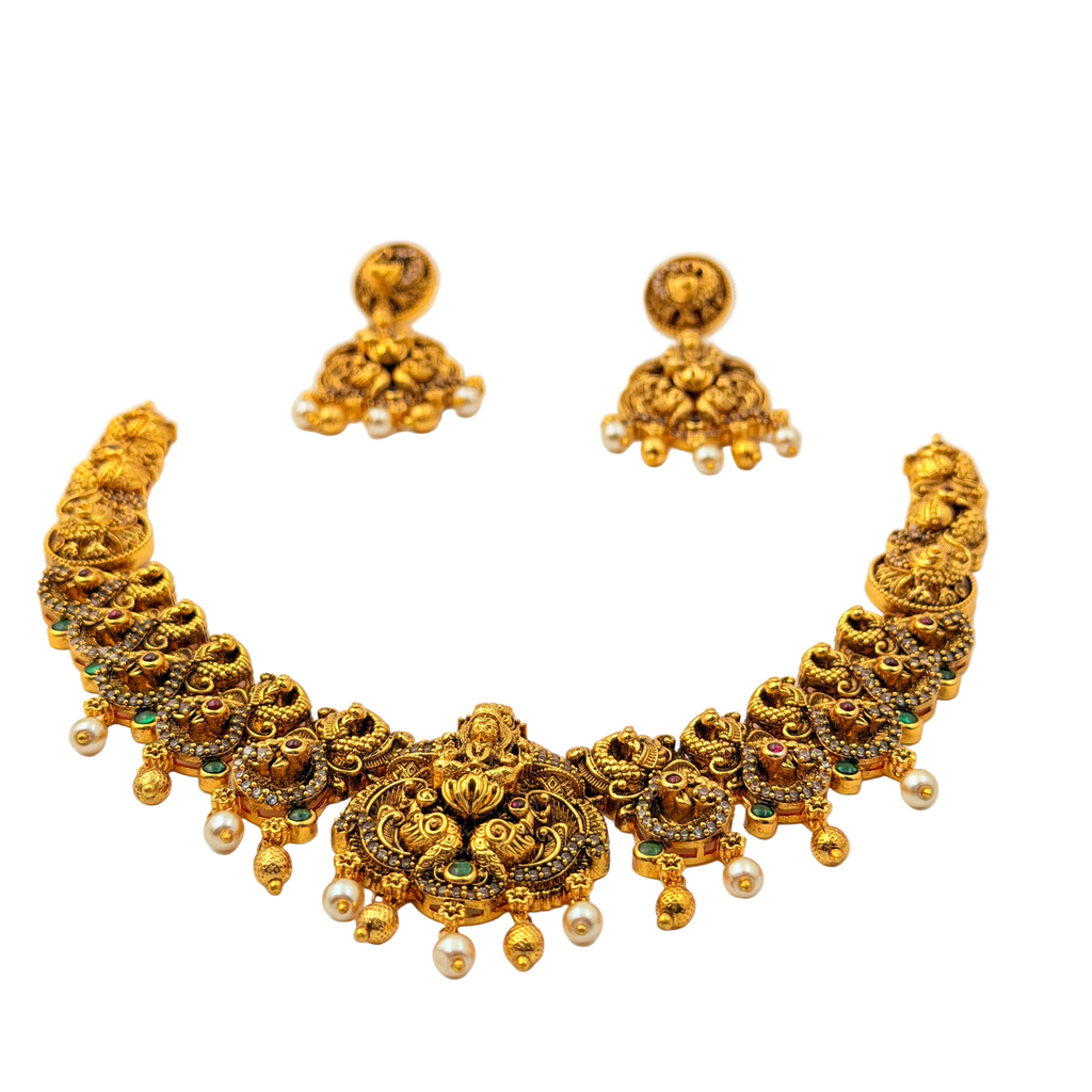 Gold necklace and earrings set on a white background