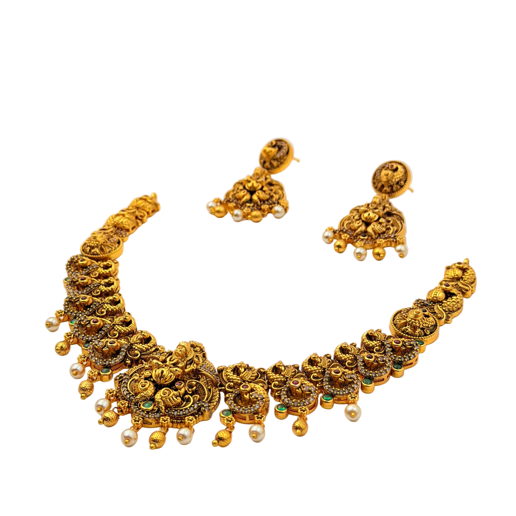 Gold necklace and earrings set on a white background