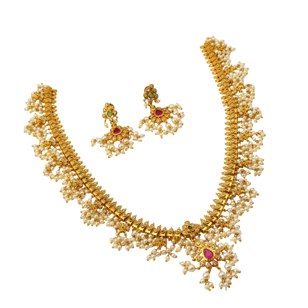 Gold necklace with pearls and gemstones on a white background