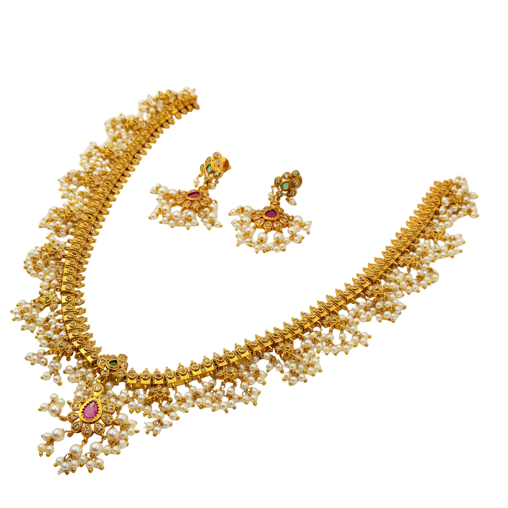 Gold necklace with pearls and gemstones on a white background