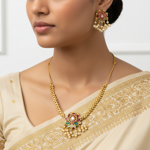 Woman wearing a gold necklace and earrings with a white background