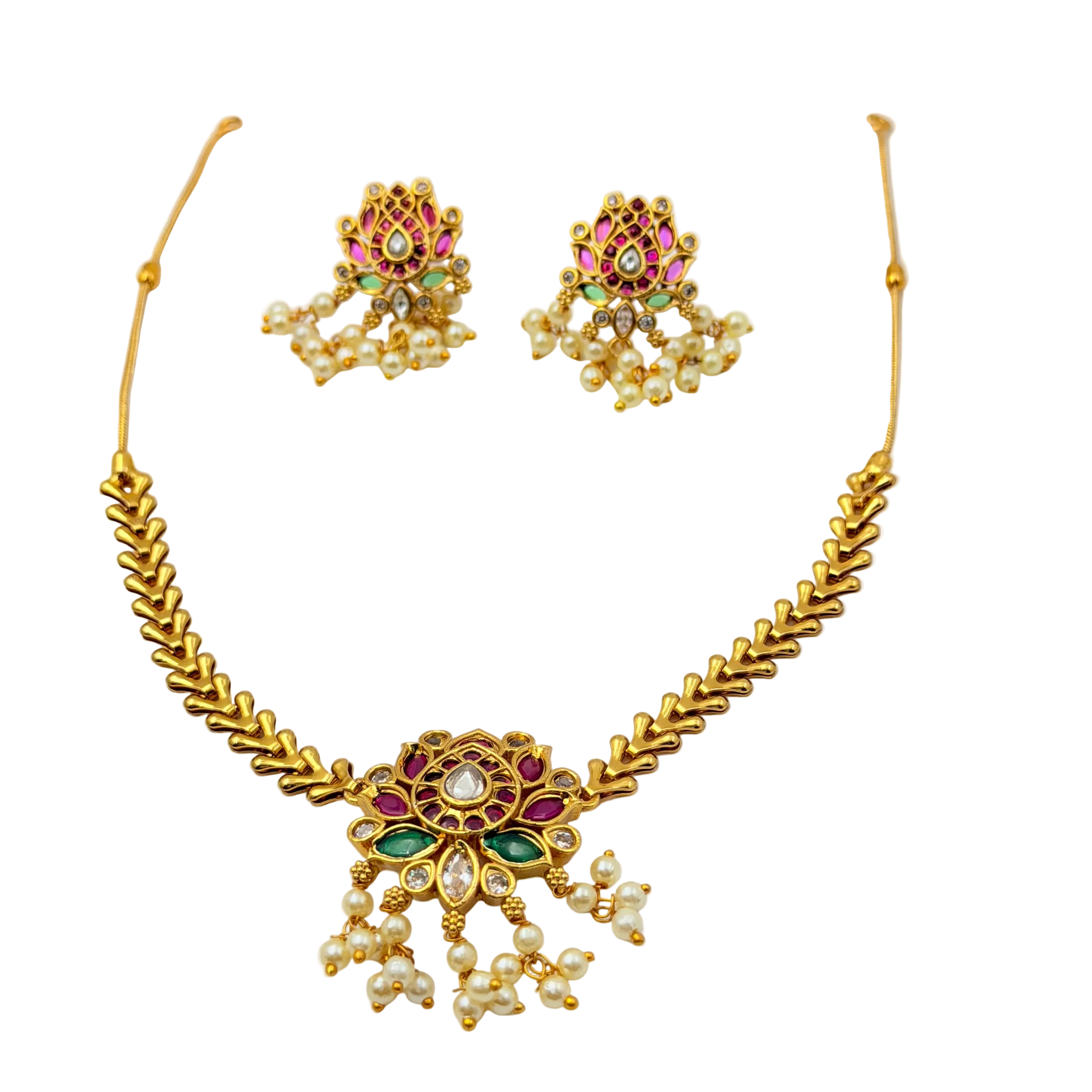 Gold necklace and earrings set with gemstones on a white background