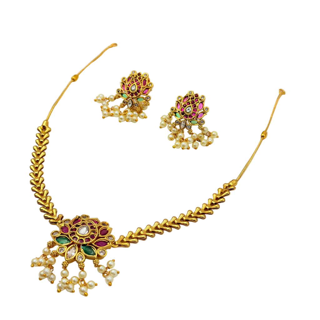 Gold necklace with floral design and pearl-like beads on a white background