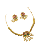 Gold necklace and earrings set with gemstones on a white background