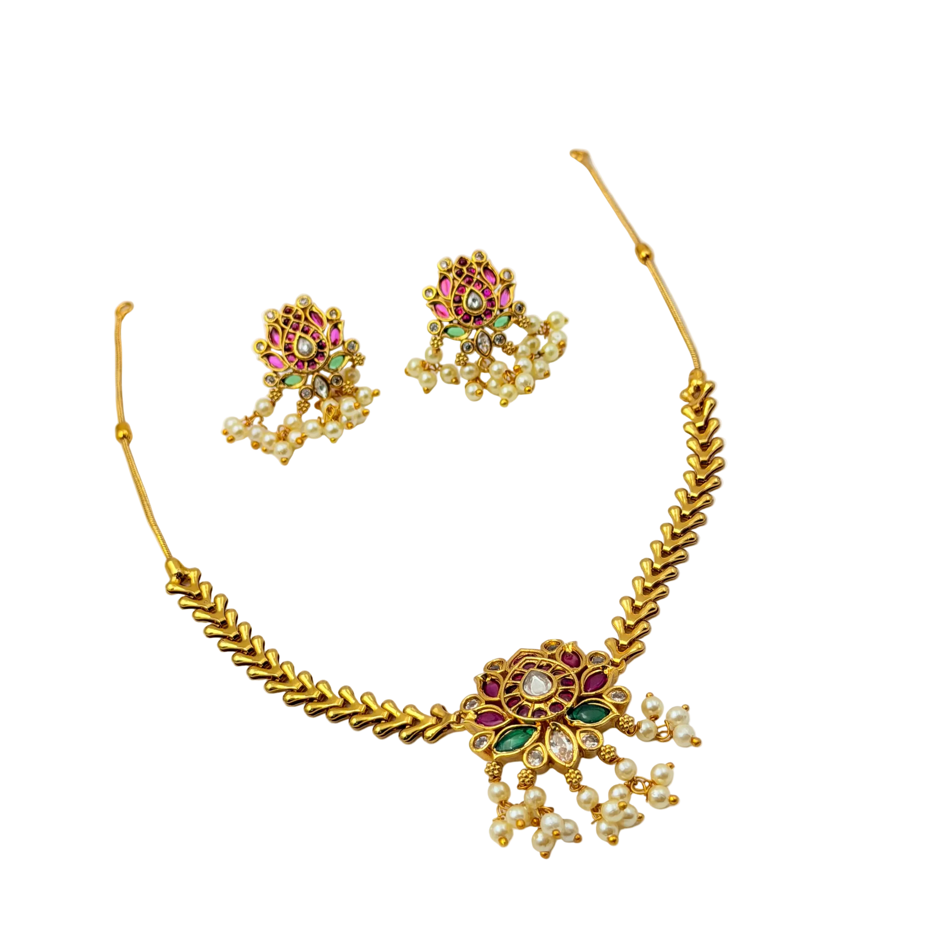Gold necklace and earrings set with gemstones on a white background
