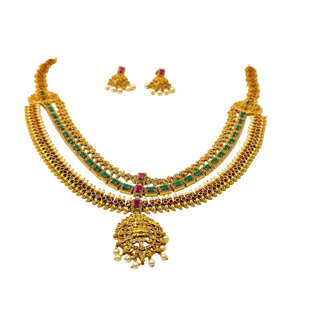 Gold necklace with green and red stones on a white background
