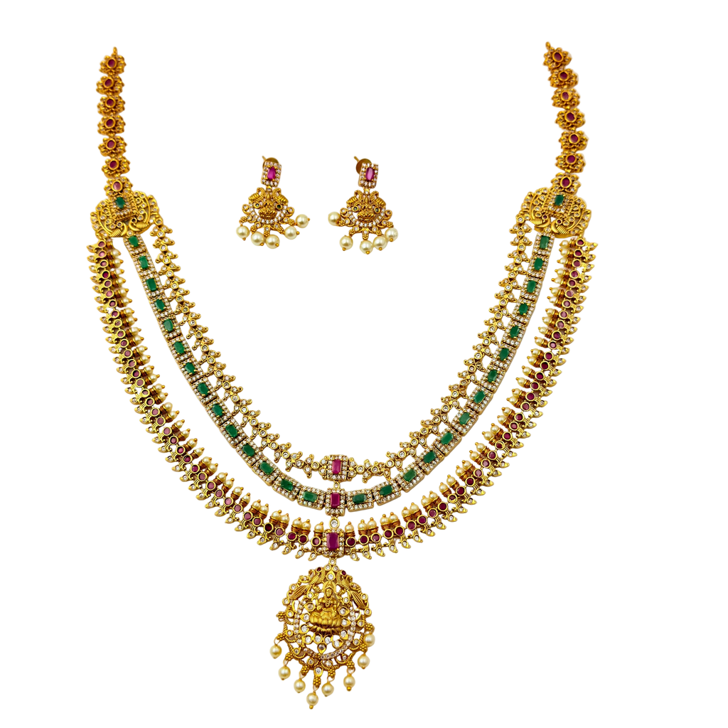 Gold necklace with green and red stones on a white background