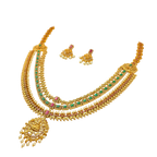 Gold necklace with green and red stones on a white background