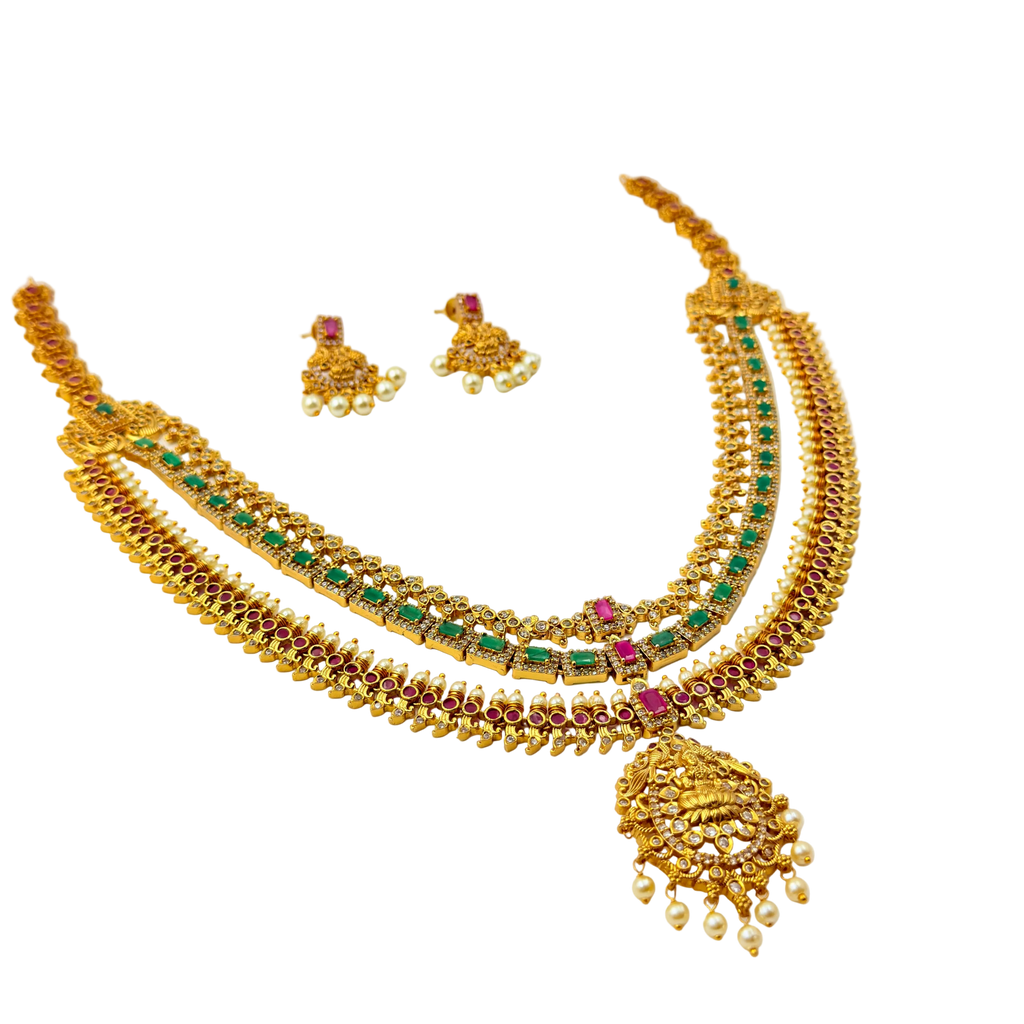 Gold necklace with green and red stones on a white background