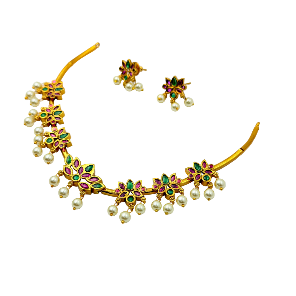 Gold necklace with pearls and gemstones on a white background