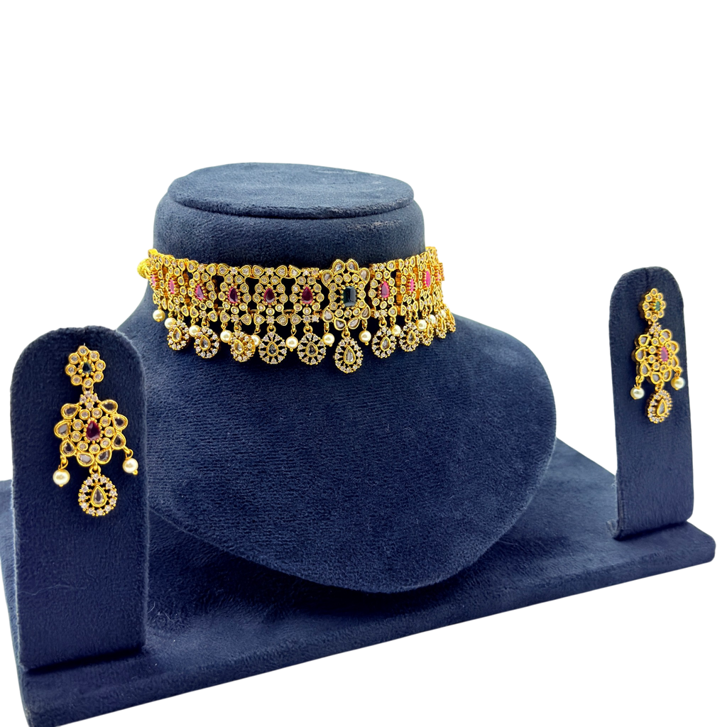Gold vintage floral choker necklace and drop earrings with ruby and emerald stones, angled display view