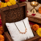 Decorative necklace in a wooden box with flowers and traditional items in the background