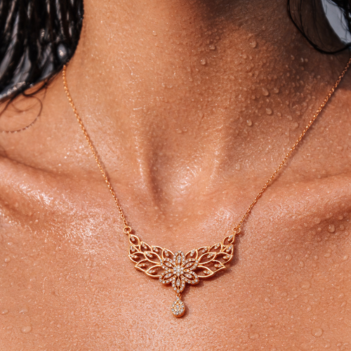 Rose gold necklace with a butterfly design on a person's neck