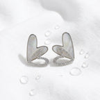 KJ-AI-GALLERY-v1 | Iridescent Double Heart Earrings — styled flat-lay | Krystal Jewels