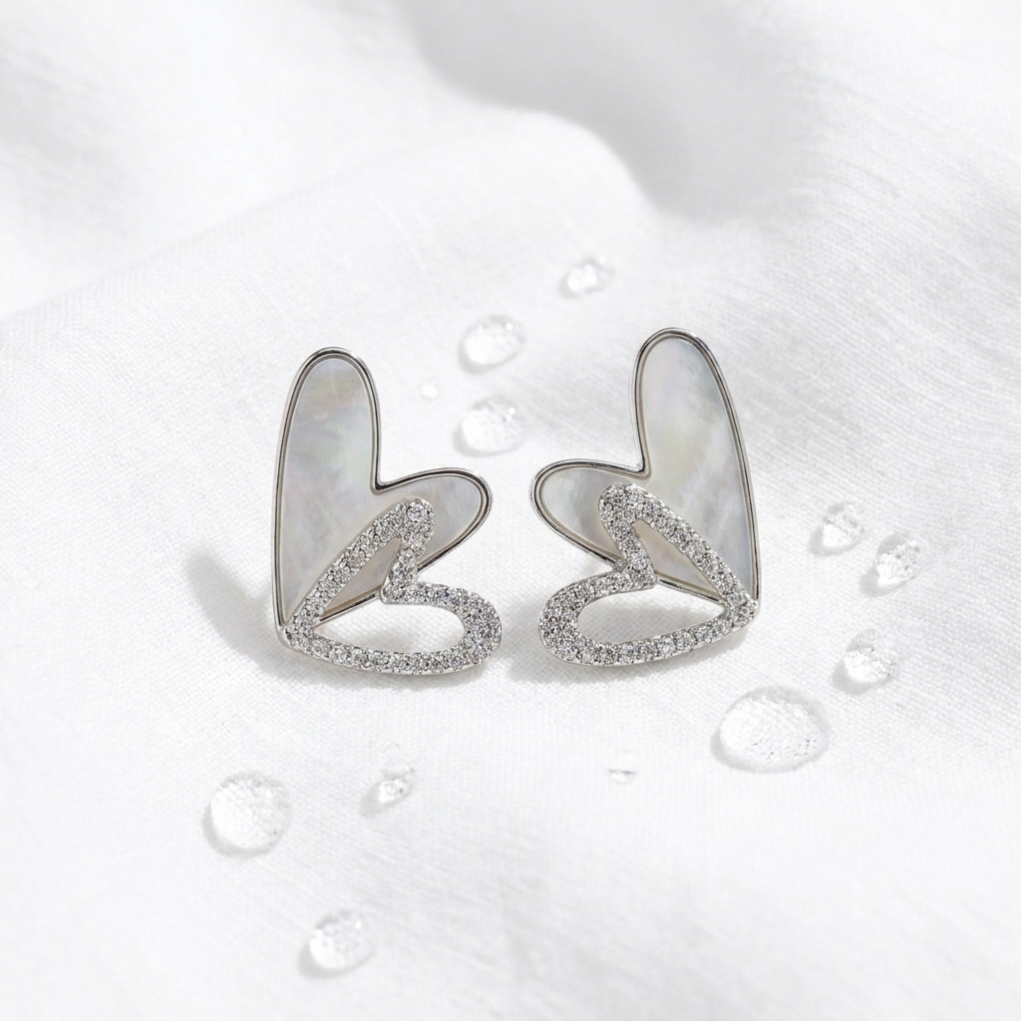 KJ-AI-GALLERY-v1 | Iridescent Double Heart Earrings — styled flat-lay | Krystal Jewels