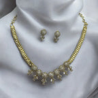 Gold-plated crystal necklace and earrings set with pave clusters, worn on model with matching ear stud