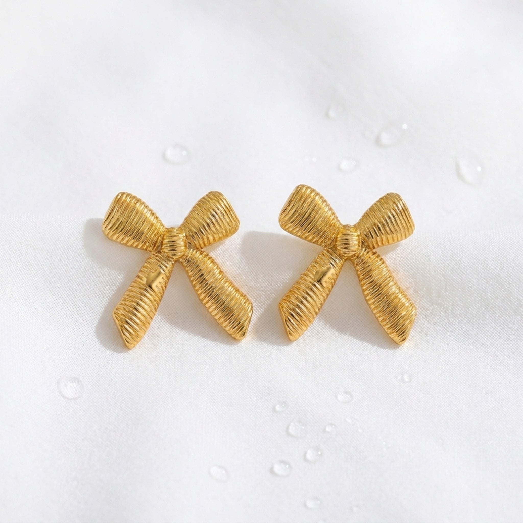 KJ-AI-GALLERY-v1 | Textured Ribbon Bow Earrings — styled flat-lay | Krystal Jewels