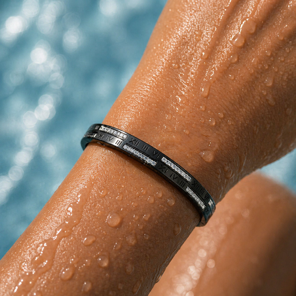 Person's wrist with a black bracelet against a blurred pool background
